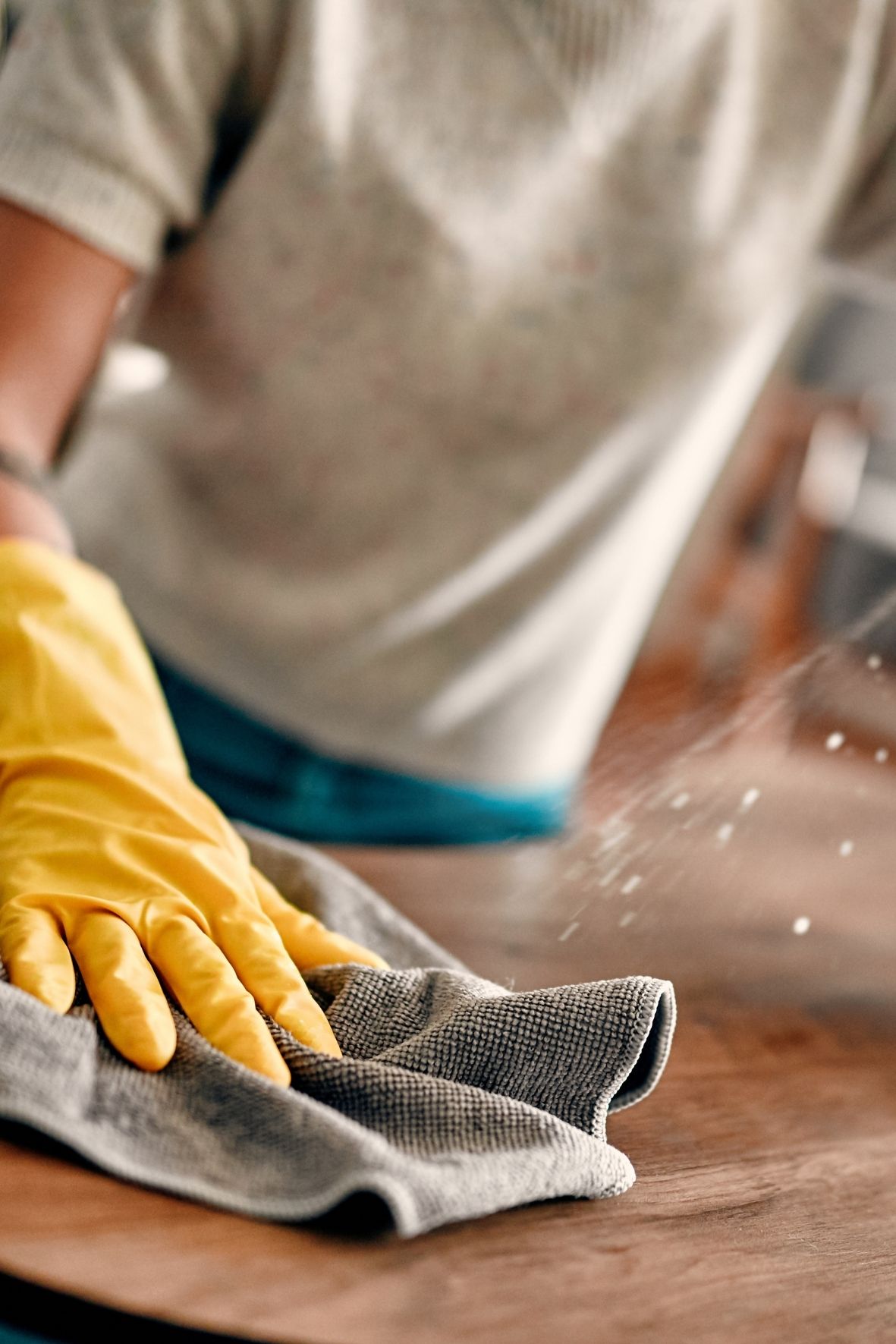 Main gantée essuyant un miroir rond dans une salle de bain lumineuse et épurée  à LaSalle